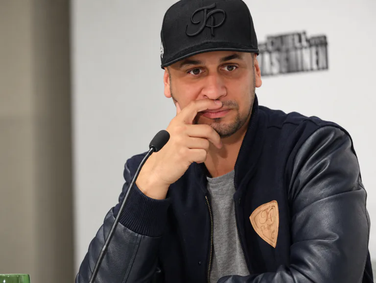 Man wearing a black JP cap beside a microphone.