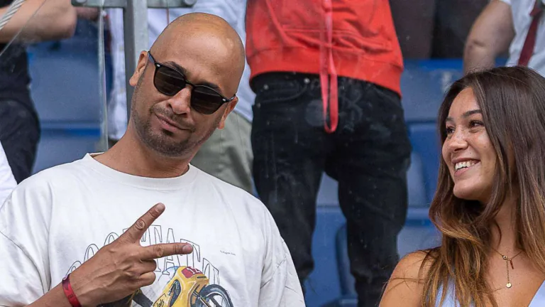 A man wearing sunglasses beside a smiling woman.