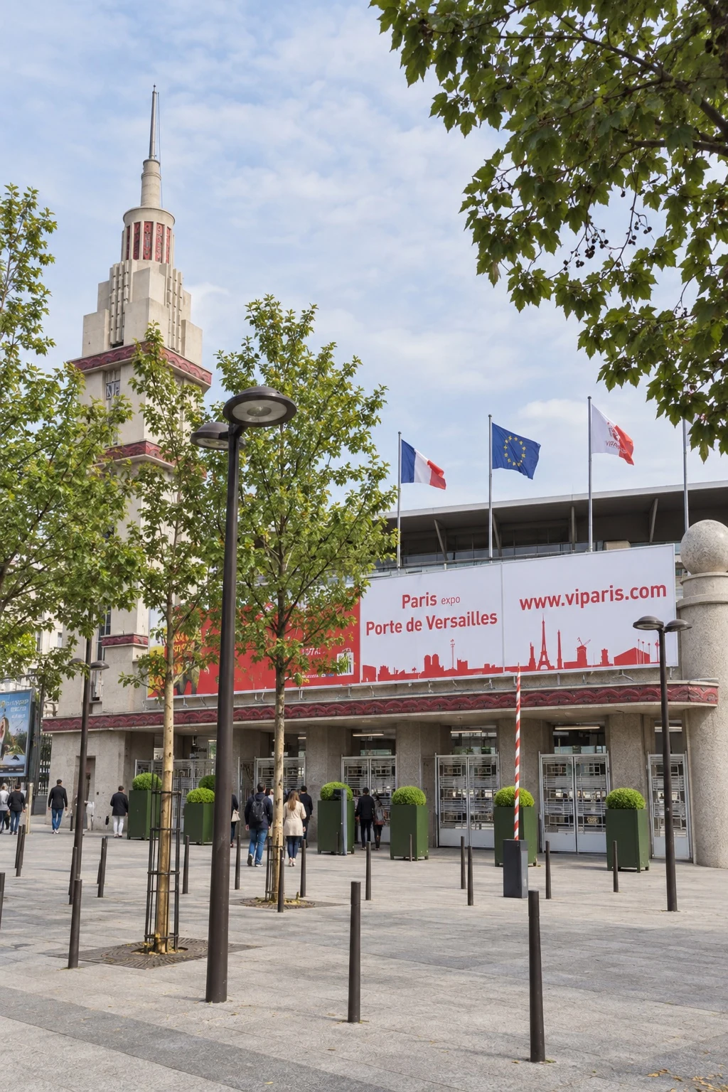 Eingang zur Paris Expo Porte de Versailles mit Turm und Flaggen.