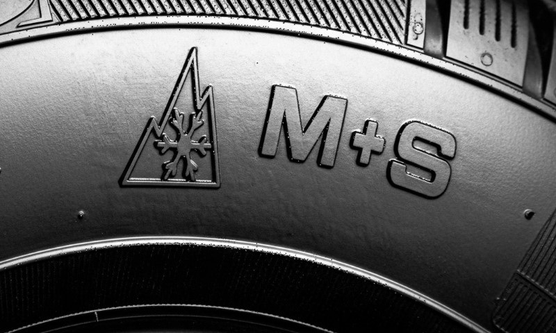 Close-up of a tyre sidewall showing the Alpine mountain-and-snowflake symbol and the M+S marking.
